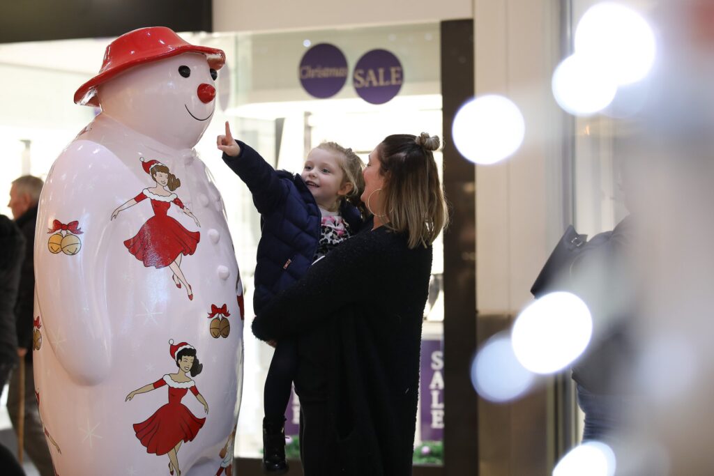 Girl and mum looking at the Walking with the Snowman sculpture. 